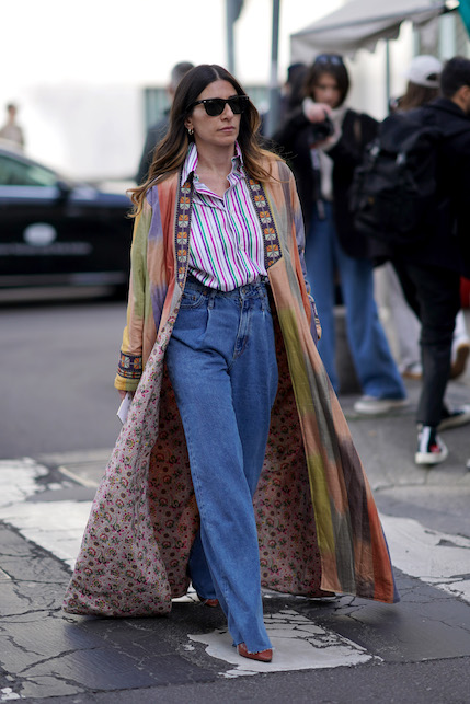 Modella con look urban chic, camicia a righe, jeans e cappotto largo