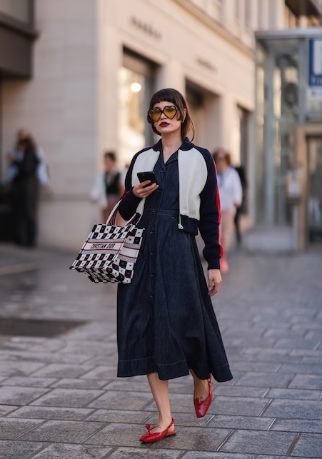 Donna con gonna a ruota blu e bomber bicolore bianco e nero
