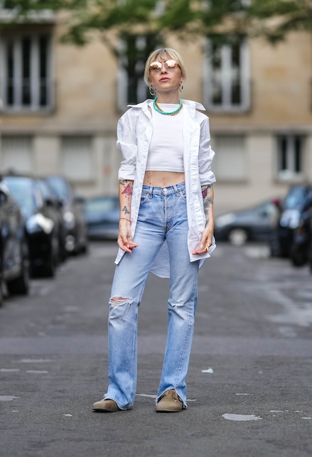 ragazza con crop top e camicia bianca e ripped jeans