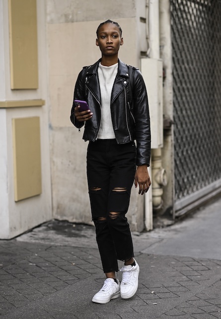 ragazza con chiodo e ripped jeans neri e t-shirt bianca
