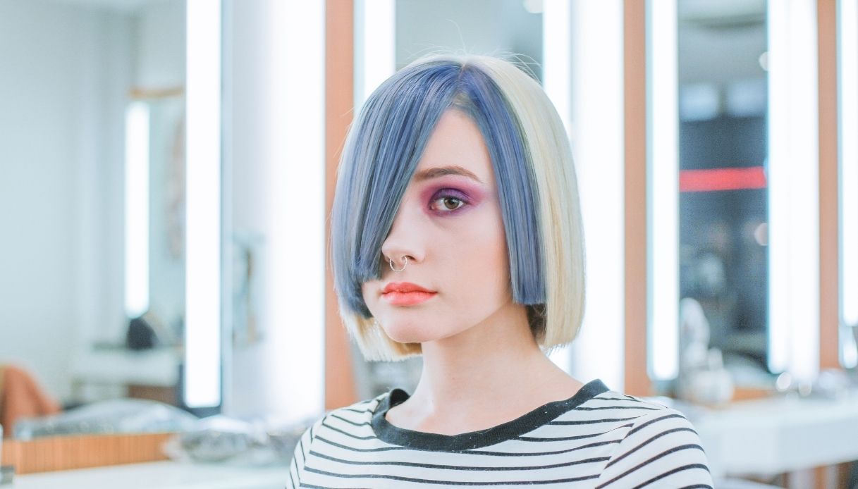 ragazza seria con caschetto di due colori biondo e azzurro e maglietta a righe bianche e nere