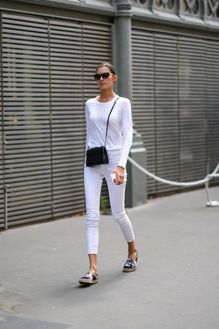 Ragazza con completo bianco e zeppe in rafia