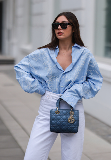 ragazza con camicia azzurra e pantaloni bianchi