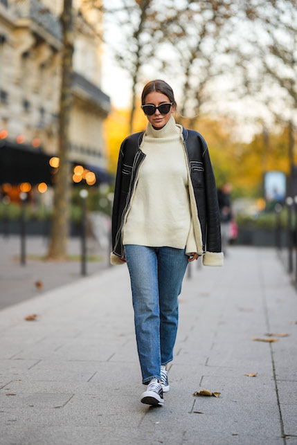 modella con pull a trapezio chiaro, mom jeans e sneakers