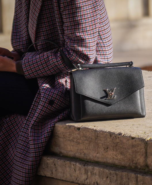 ragazza con giacca a quadri e borsa nera