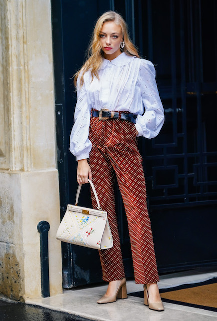 ragazza con camicia bianca e pantaloni in fantasia marroni