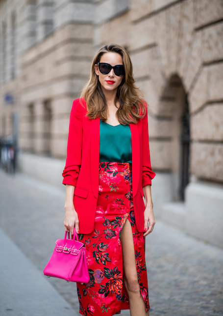 donna che indossa gonna lunga a fiori rossa, blazer rosso e top verde