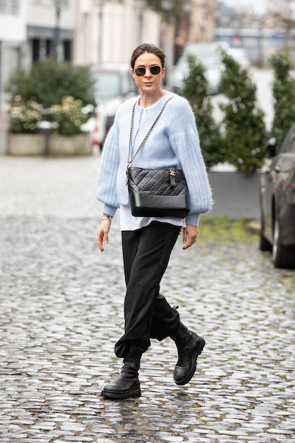ragazza con cardigan azzurro e pantaloni neri