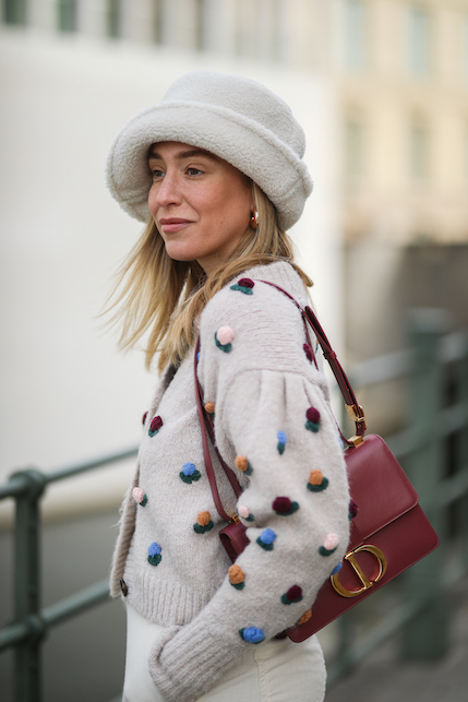 ragazza con cardigan lavorato, borsa bordeaux e cappello