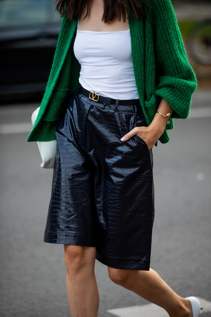 ragazza con cardigan verde, top bianco e bermuda nero