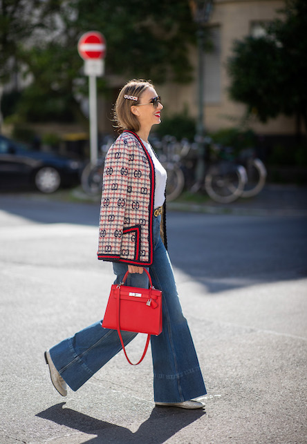ragazza con jeans, borsa rossa e cardigan in fantasia
