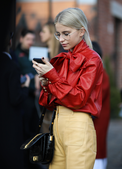 ragazza con camicia lavallière rossa e pantalone beige