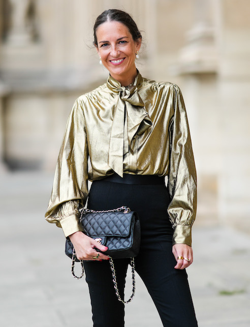donna con camicie lavallière dorata e pantaloni neri