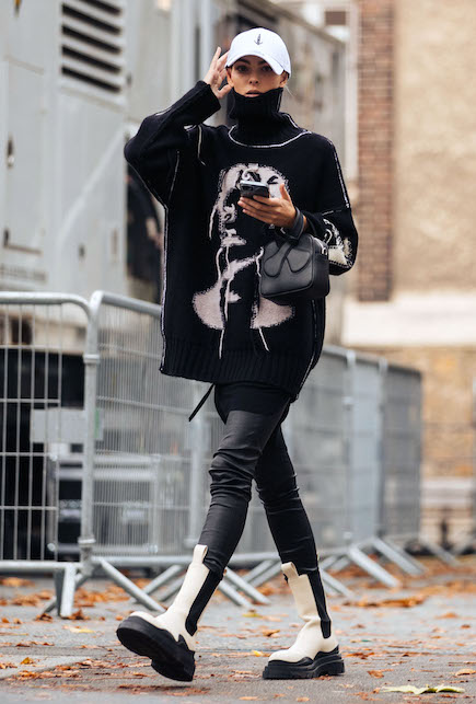 Vittoria Ceretti con chunky boots, maglia stampata, pantaloni neri e berettino