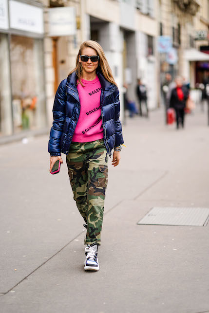ragazza con pantaloni camouflage, felpa fucsia e piumino blu