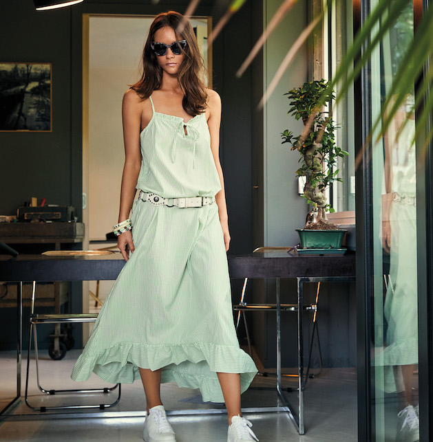 Ragazza con abito verde menta e sneakers