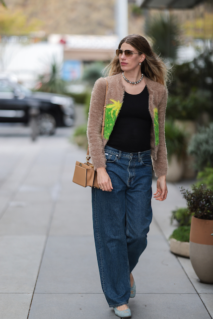 ragazza con jeans, borsa beige e top nero