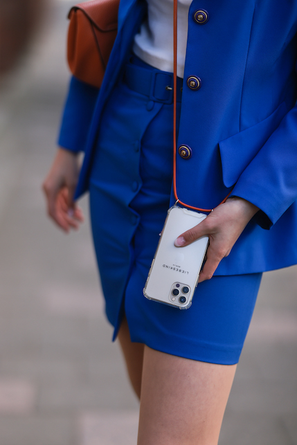 ragazza con completo bluette e catenella al cellulare
