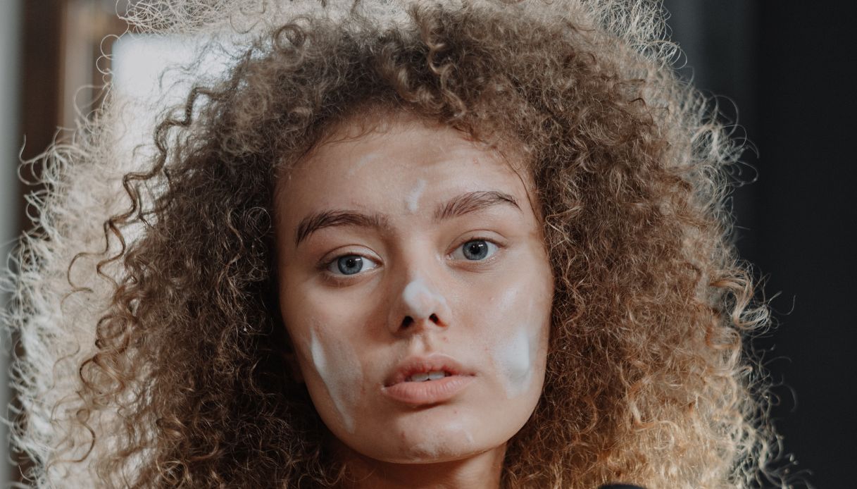 ragazza bionda riccia con sguardo assente ha schiuma sul viso