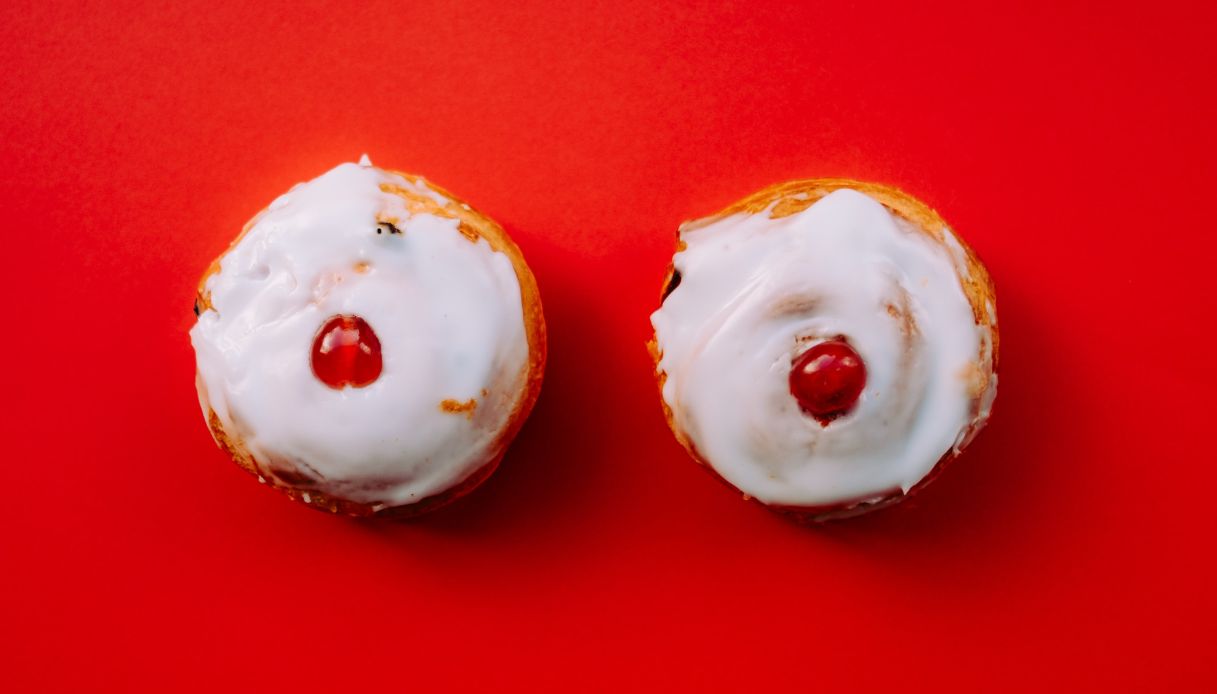 pasticcini su sfondo rosso con glassa bianca e ciliegina rossa al centro