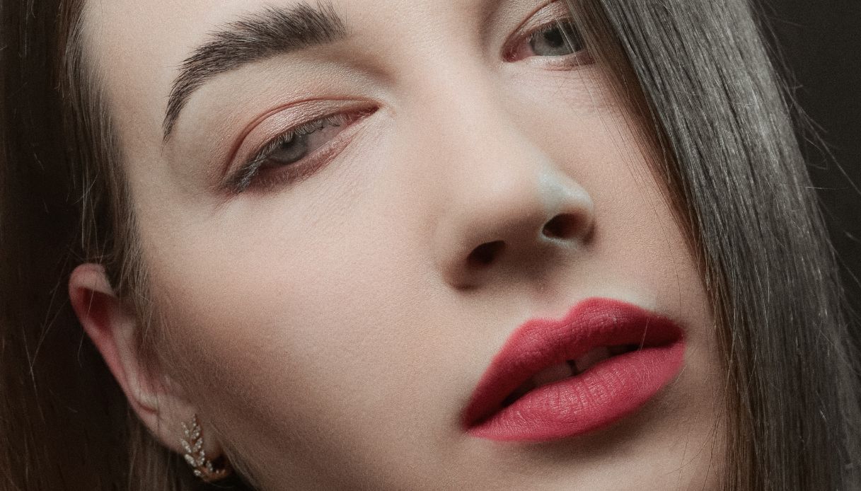 ragazza pelle chiara con occhi azzurri e capelli castani con rossetto rosa