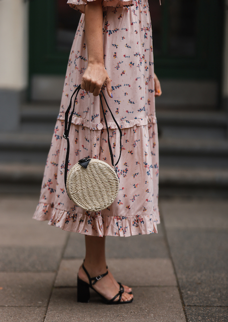 ragazza con abito rosa e borsa di paglia