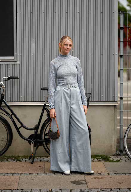 ragazza con pantaloni palazzo grigi e top grigio