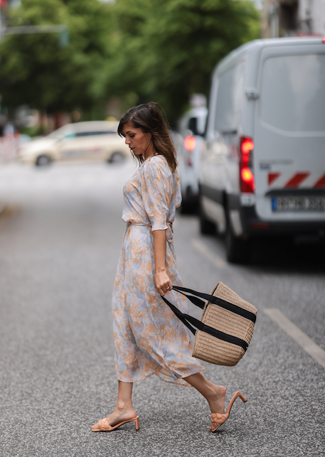 ragazza con abito leggero e borsa di paglia