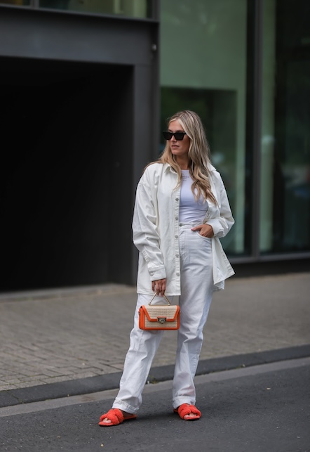 ragazza con jeans bianchi e borsa arancione
