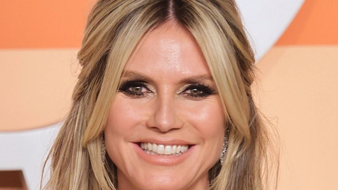 Heidi Klum, gonna cortissima e dettagli piumati: il look color cioccolato è super sensuale