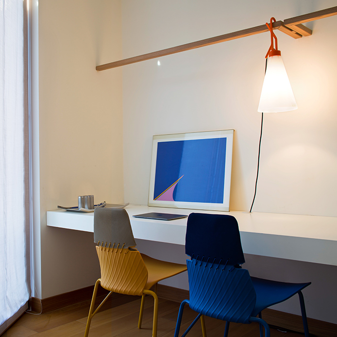 Lo studio gioca con geometrie e cromie: sedie Zigozago, lampada May Day e opere d’arte concettuali animano un ambiente creativo e ordinato
