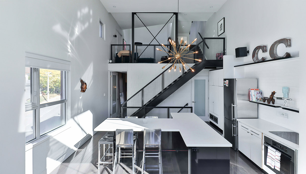 Un loft moderno sfrutta la verticalità con un soppalco e arredi essenziali