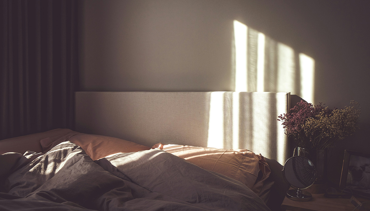 Una scena intima, fatta di coperte leggere, fiori secchi e luce radente. L’arredamento che parla alla pelle e al cuore