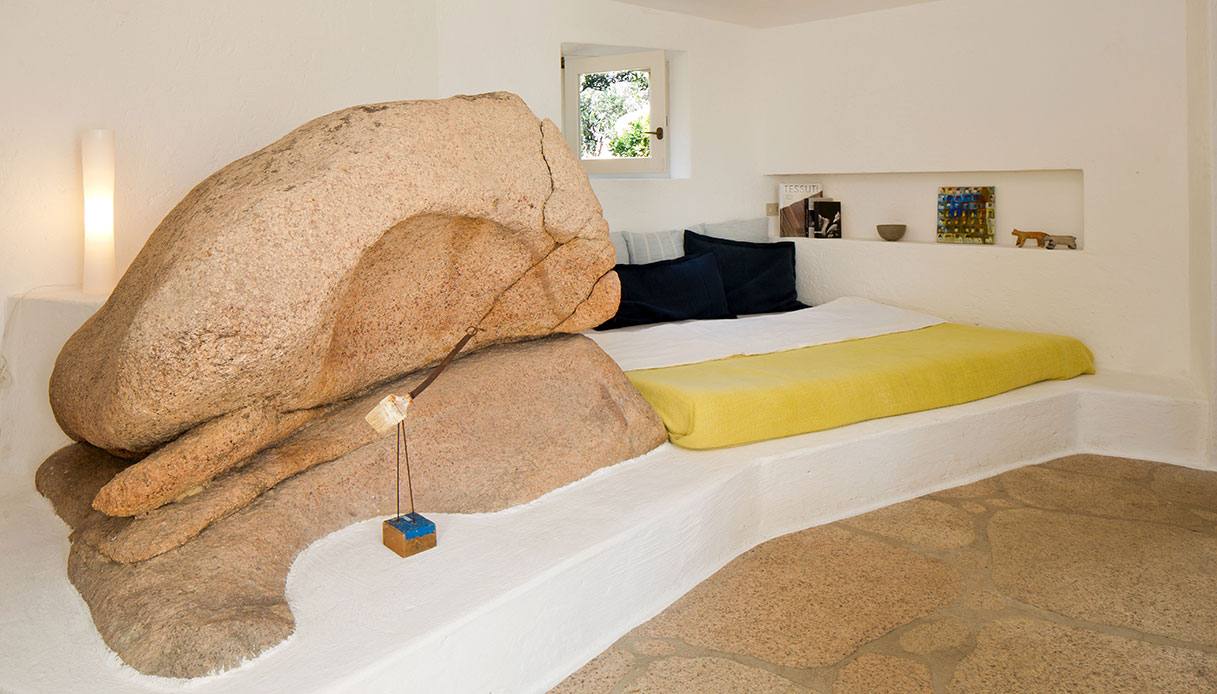 Il letto in muratura modellato attorno a una roccia naturale: design e paesaggio diventano uno