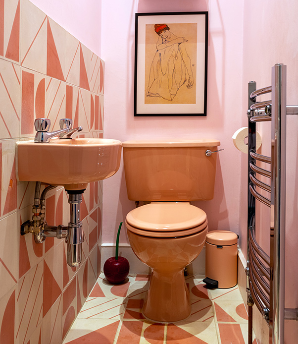 Sanitari color pesca e geometrie vintage per un bagno che racconta chi lo abita