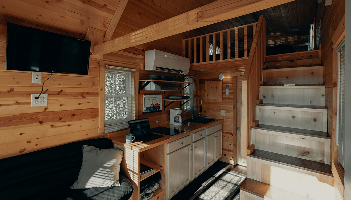 interno in legno con letto a soppalco e scala salvaspazio