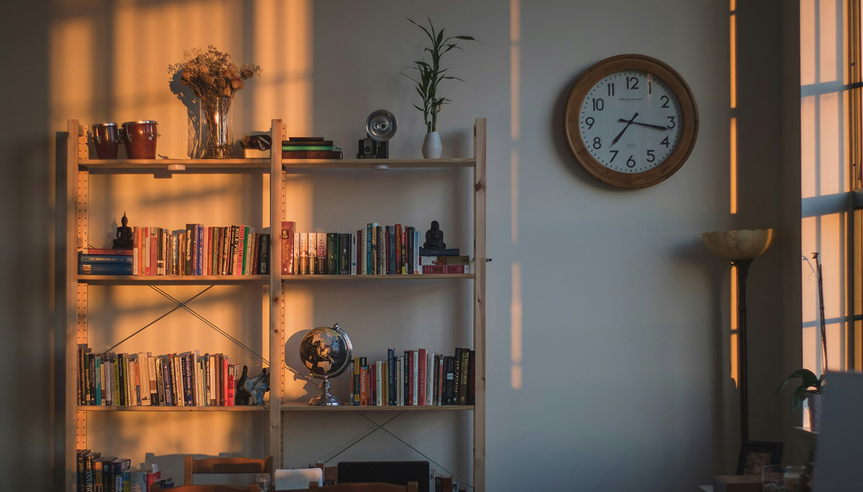 libreria verticale in legno con libri e oggetti decorativi