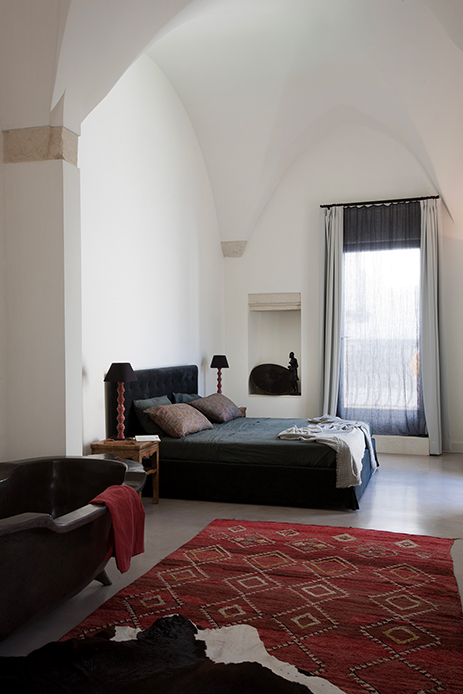 Camera da letto con letto imbottito, tappeto rosso geometrico