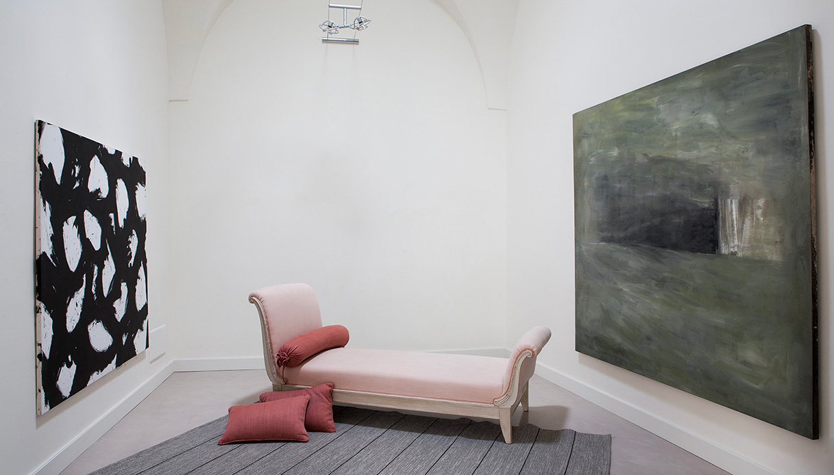 Chaise longue rosa con cuscini e grandi quadri