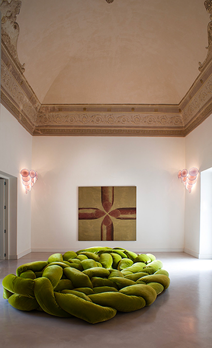 Divano verde intrecciato al centro di una sala