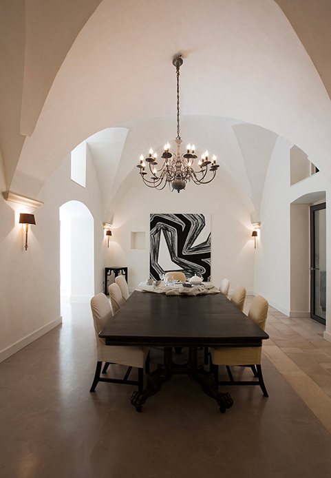 Sala da pranzo con tavolo apparecchiato, sedie rivestite