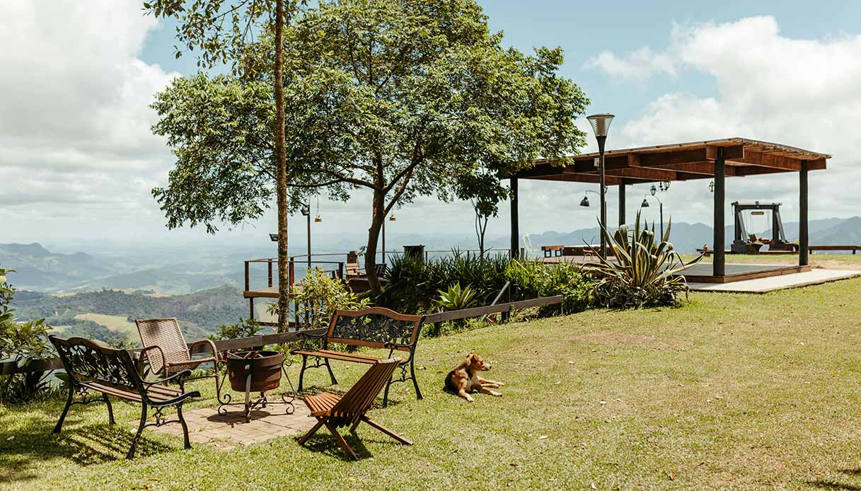 Gazebo in legno su prato con vista sulle colline e arredi da esterno