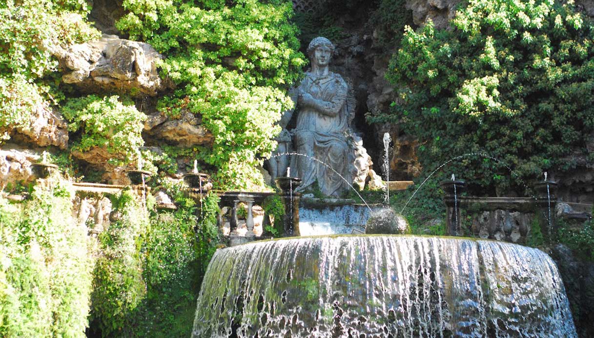 Statua femminile circondata da vegetazione e getti d’acqua nella fontana di Villa d’Este