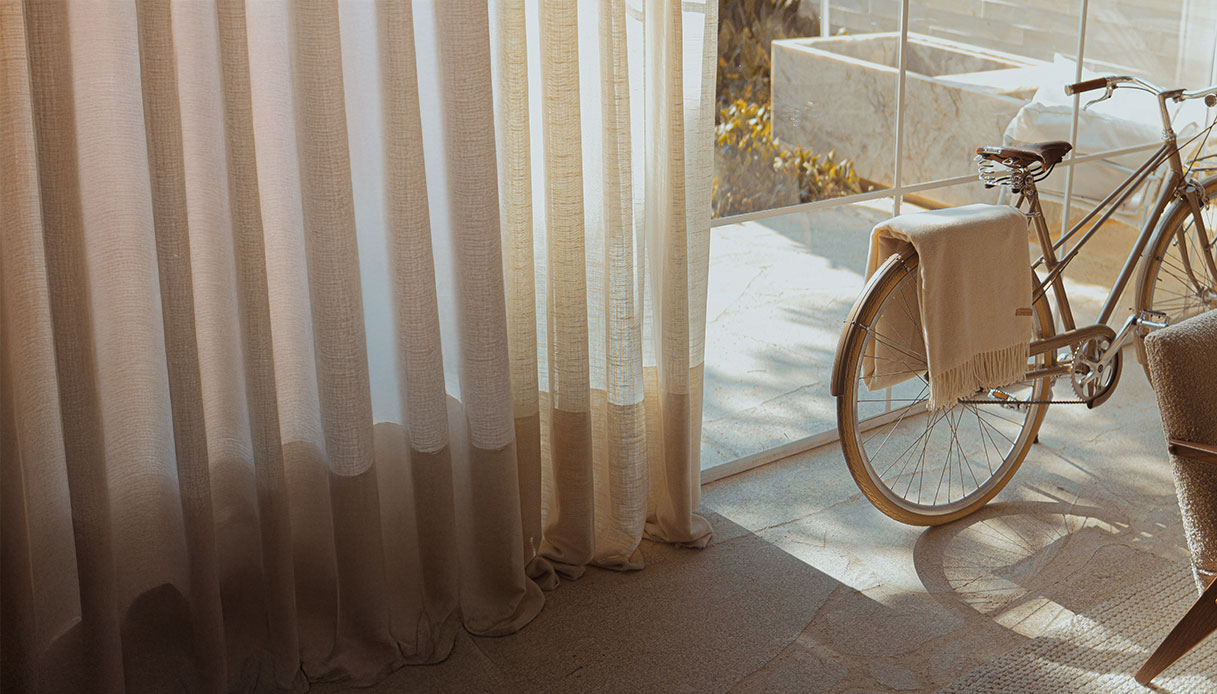 Tende leggere color sabbia e bicicletta vintage