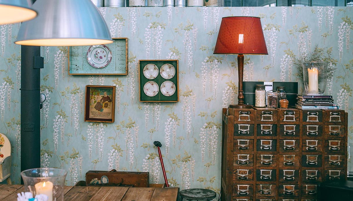 Interno rustico moderno con cassettiera in legno e carta da parati floreale