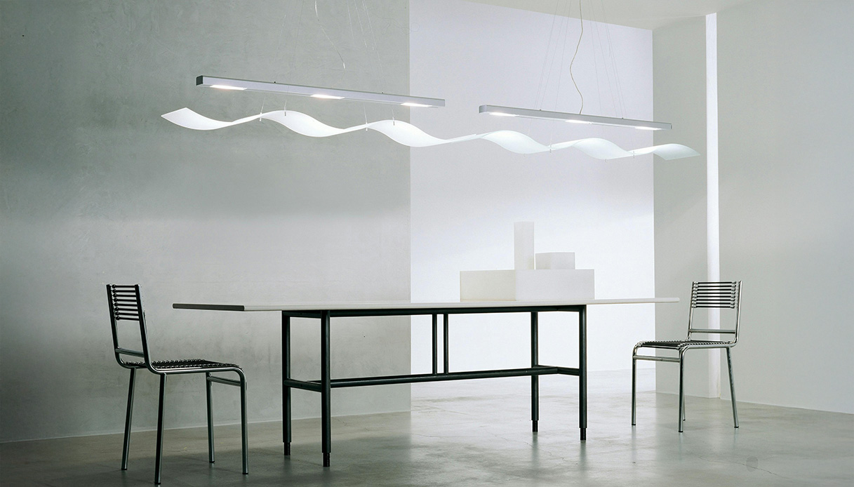 Interno minimal moderno con tavolo, sedie metalliche e lampada di design